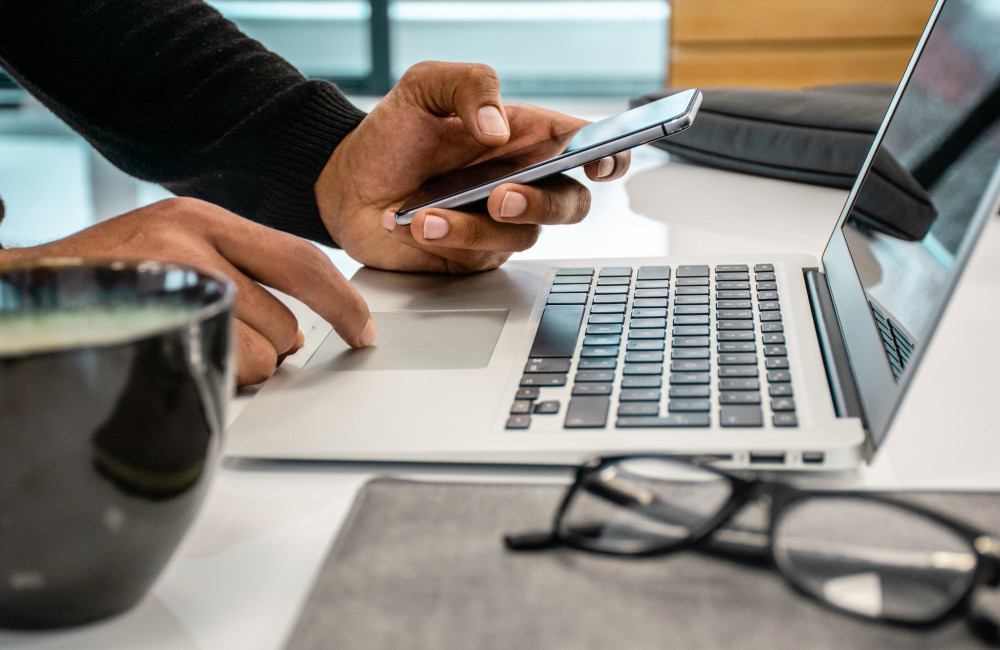 Man using laptop and mobile phone on desk