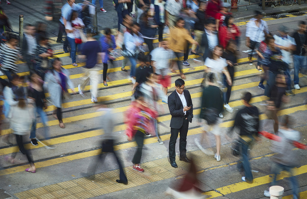 Business man in crowd using mobile phone