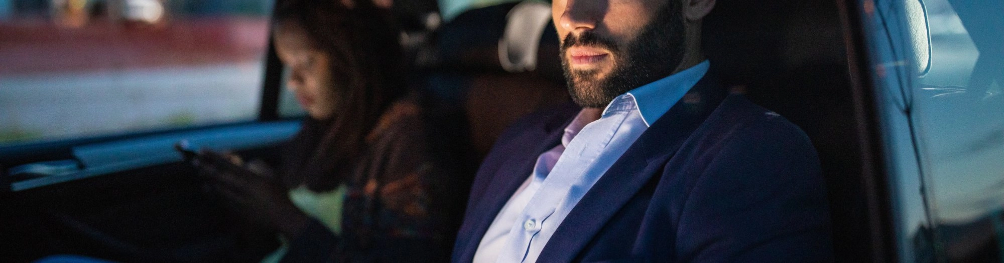 Business travelers in the back of a car at night