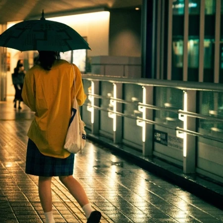 Person walking with an umbrella in heavy rain at night