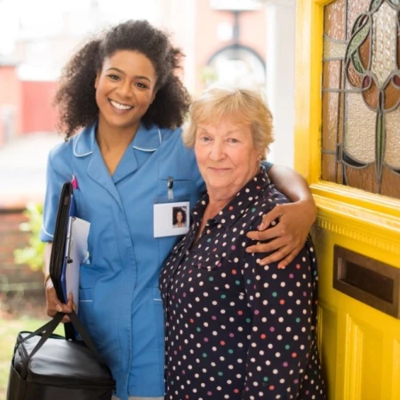 Community care worker with a patient at her front door