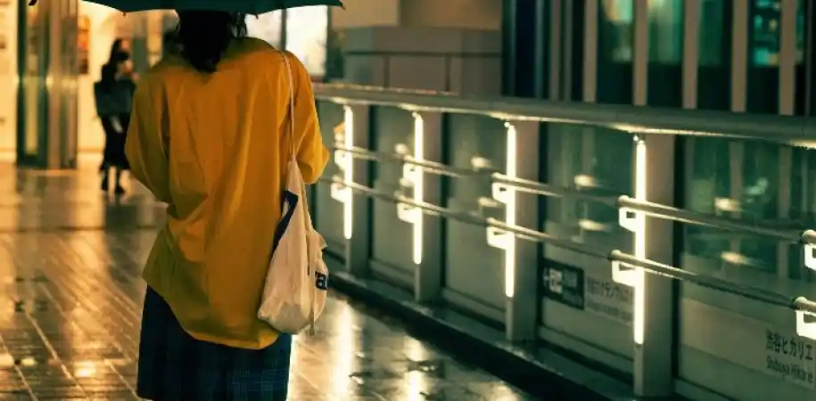 Person walking with an umbrella in heavy rain at night