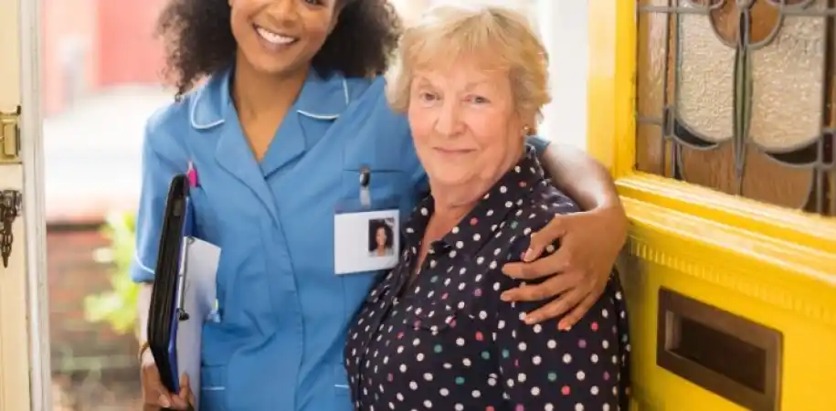 Community care worker with a patient at her front door