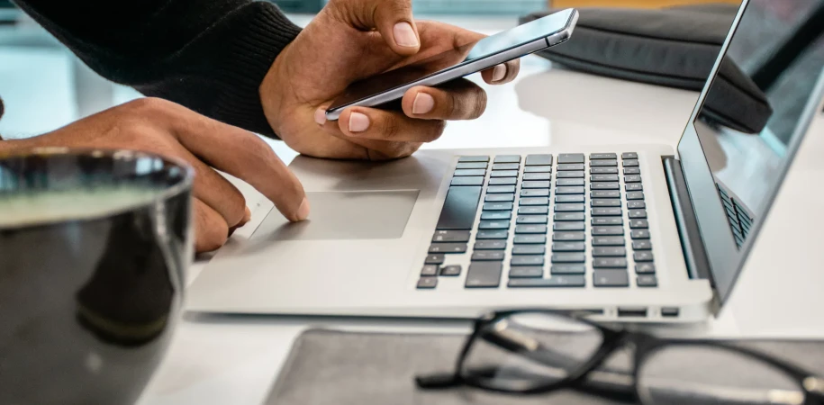 Man using laptop and mobile phone on desk