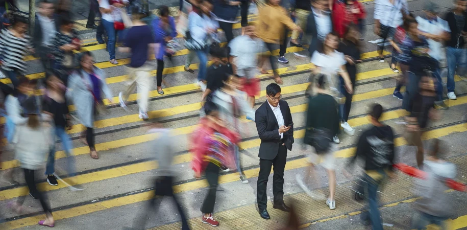 Business man in crowd using mobile phone