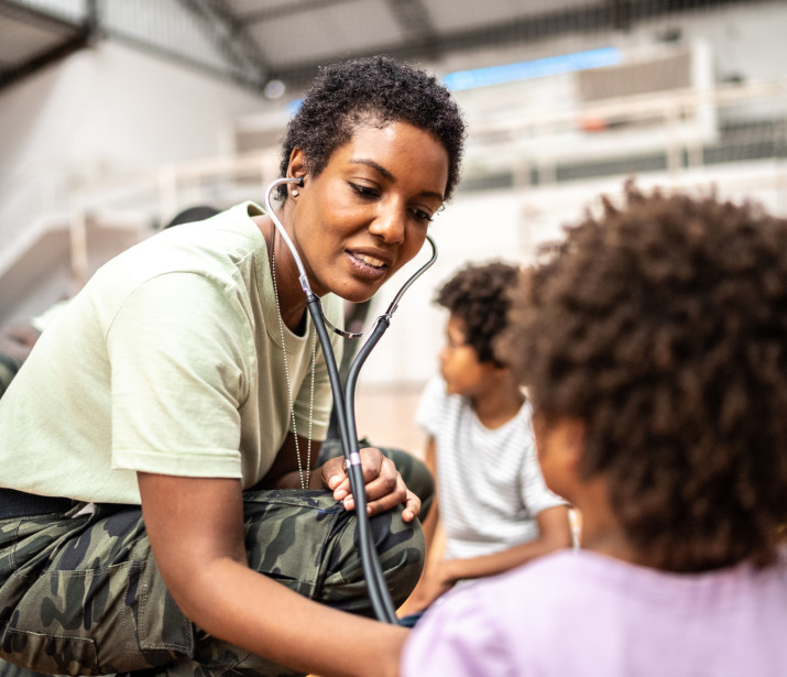 Army doctor examining child