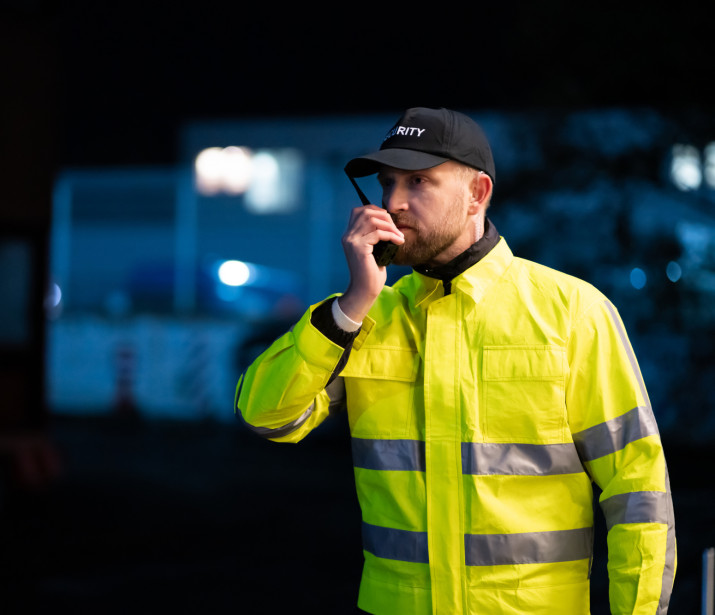 Security Guard Talking On Walkie-talkie at Night