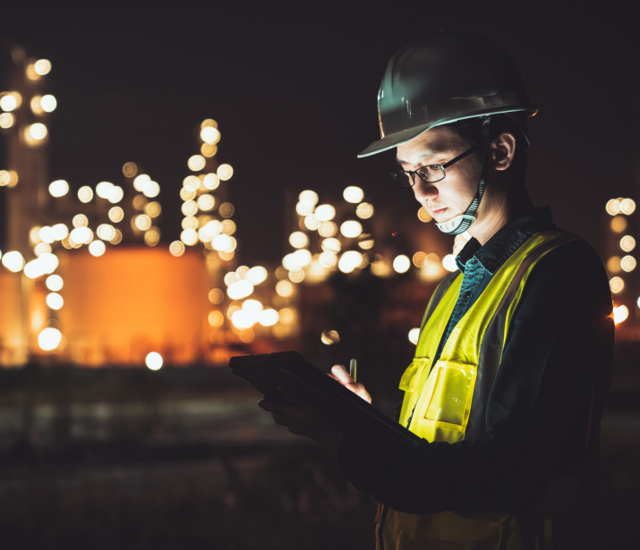 Engineer using digital tablet working late